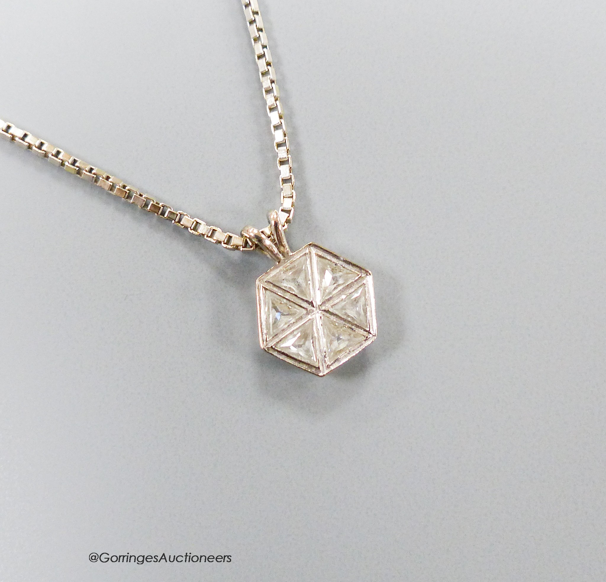 A white metal and six stone triangular diamond set hexagonal pendant, 9mm, pendant on an Italian 18ct white gold chain, 46cm, gross 6.4 grams.